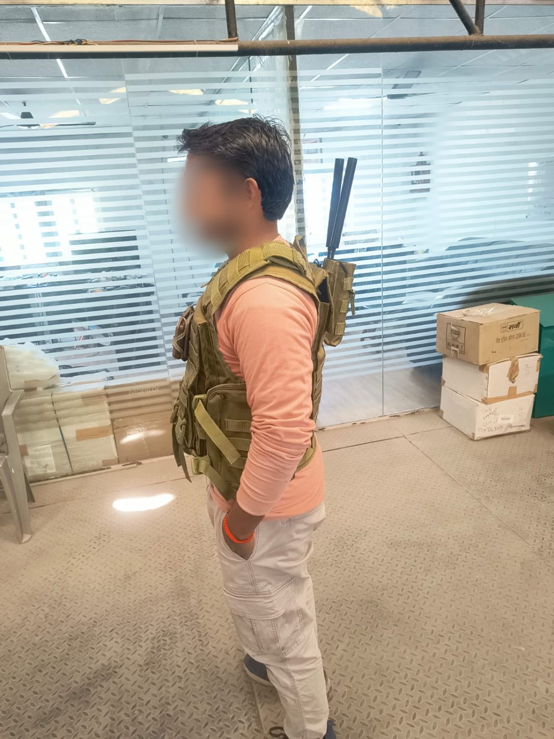 Side view of an operator in a plate carrier, two antennas stowed vertically in a rear pouch