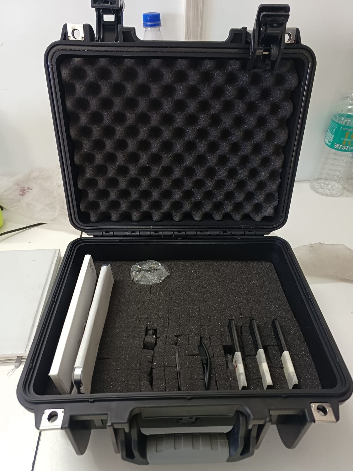 Transit case with empty custom-cut foam inserts shaped to each item in the kit