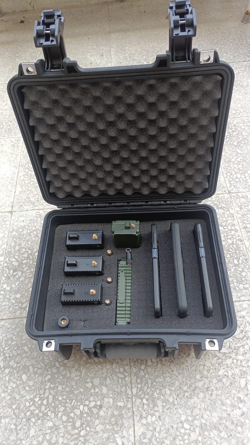 Open transit case with custom-cut foam holding mesh nodes, a mast node, spare antennas and rugged handhelds