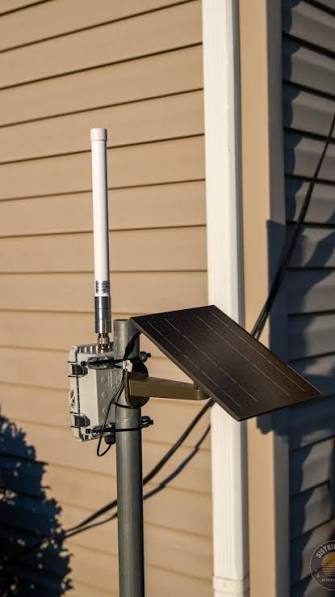 Solar-powered relay node with antenna mounted on a pole
