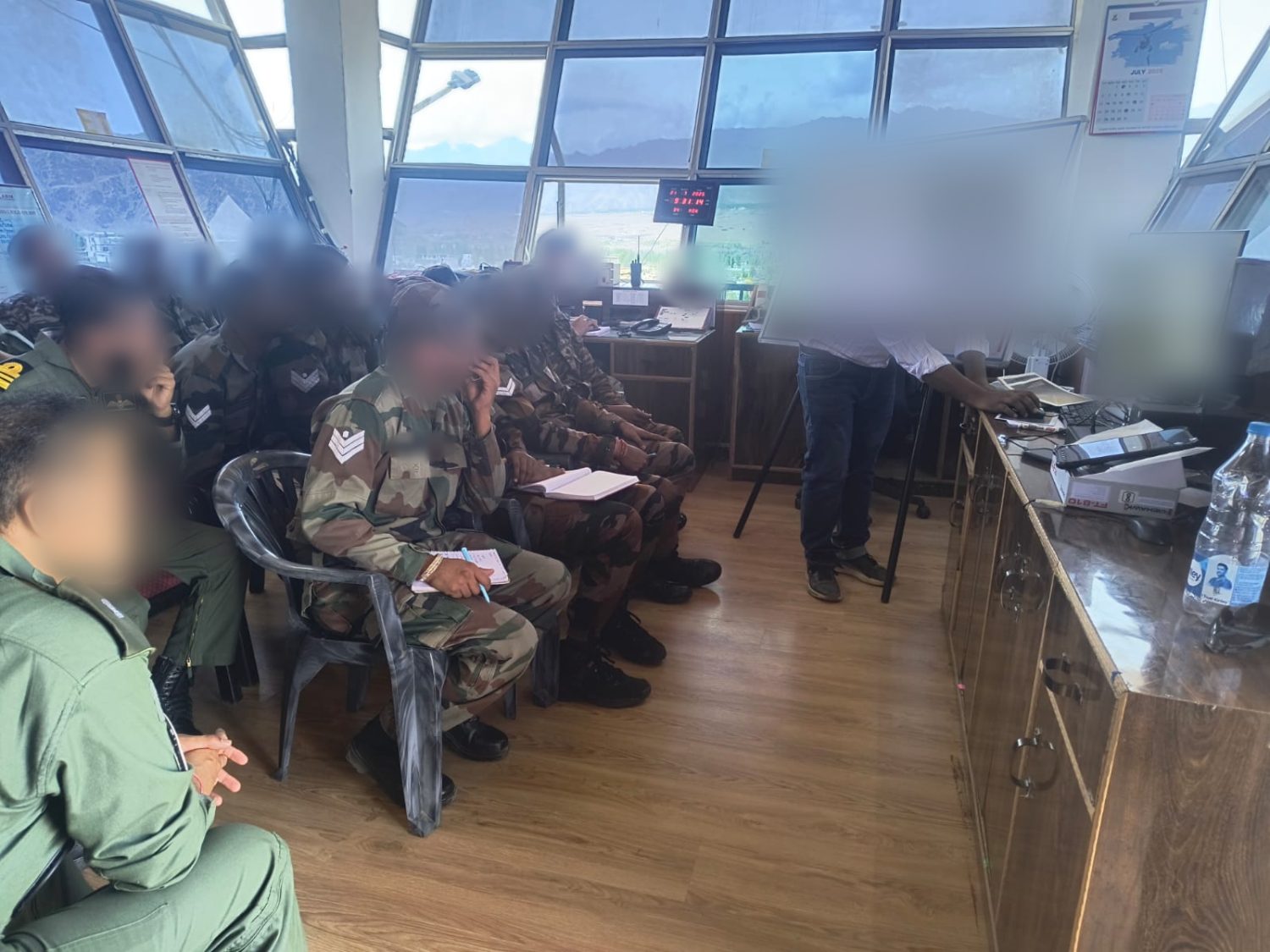 Operator training in a control tower, instructor at a whiteboard and workstation