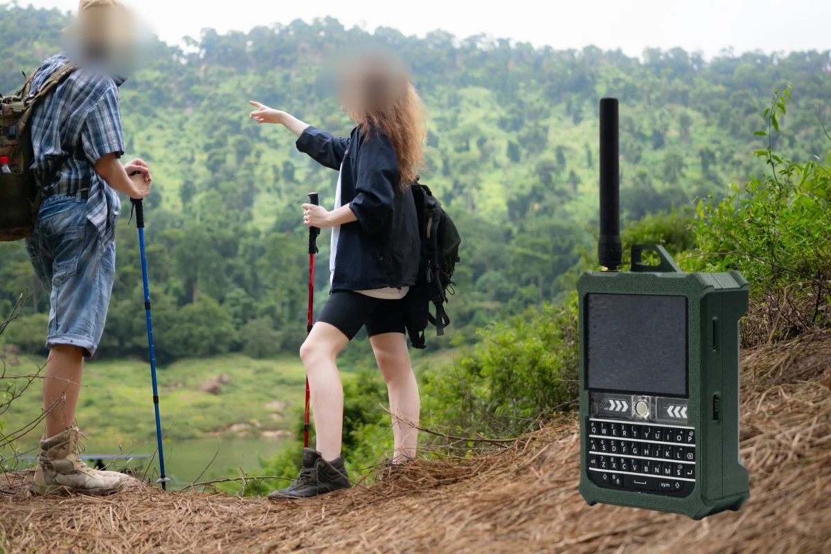 Two walkers on a hillside beside a handheld mesh node